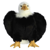 A brown and white eagle plush toy from Aurora with a yellow beak and realistic feather accents.