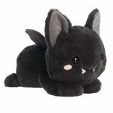 Plush bat with belly-down posture and sprawling arms, featuring gentle eyes and soft fur.