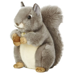 A grey squirrel plush toy from Miyoni by Aurora with a fluffy tail and an acorn between its paws.