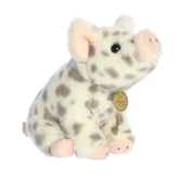 A soft pink plush piglet with gray spots in a seated pose from Miyoni Tots by Aurora.