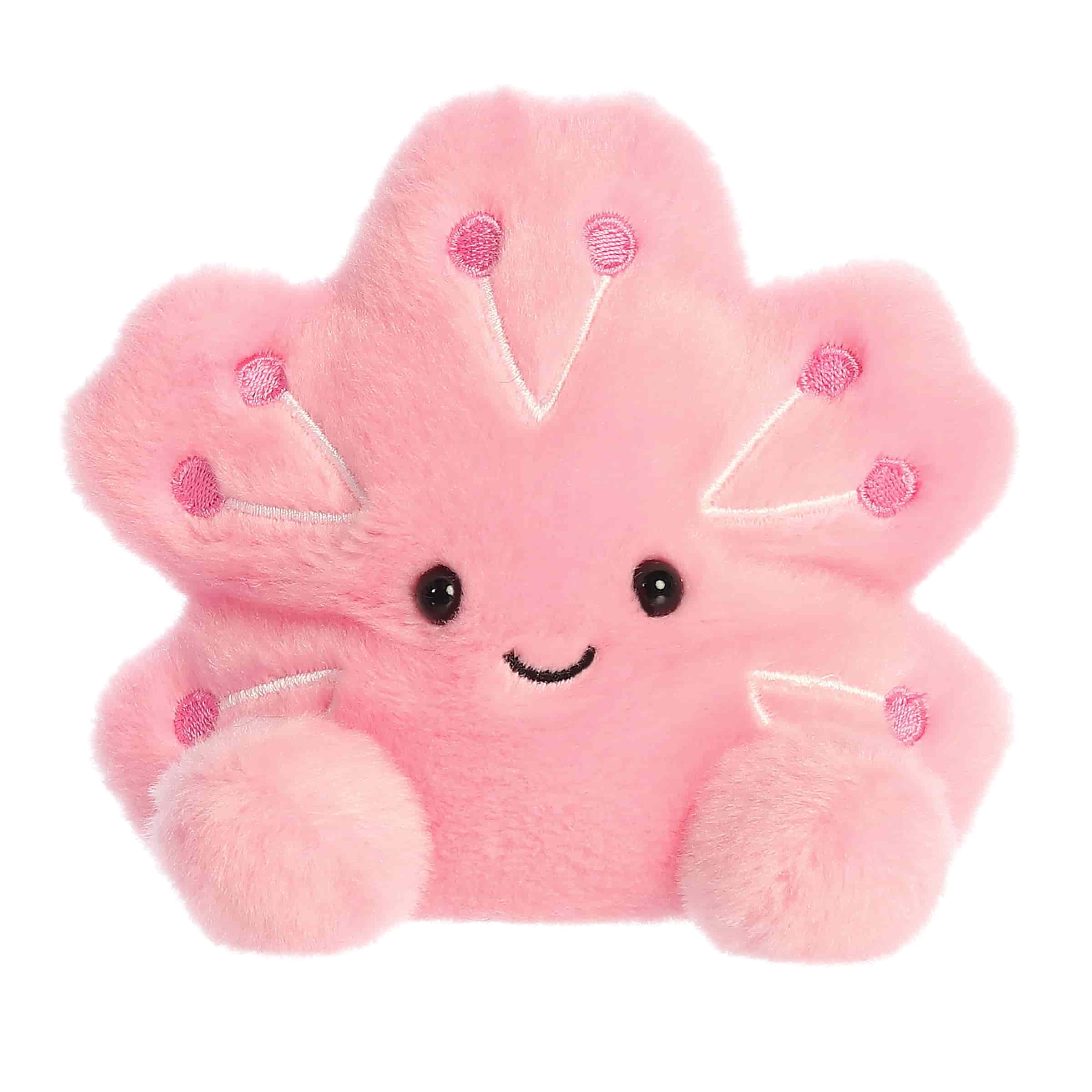 Plush toy of a pink cherry blossom by Palm Pals with purple dots, petal arms, and a gentle smiling face.