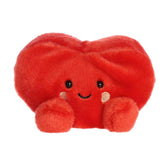 A small red heart plush with rosy cheeks and a sweet smile from Palm Pals by Aurora.