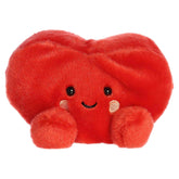 A small red heart plush with rosy cheeks and a sweet smile from Palm Pals by Aurora.