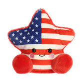 A small red, white, and blue star plush with pink cheeks from Palm Pals by Aurora.