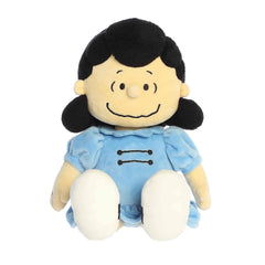 A Lucy plush wearing a blue dress with black hair and a confident smile from the Peanuts collection