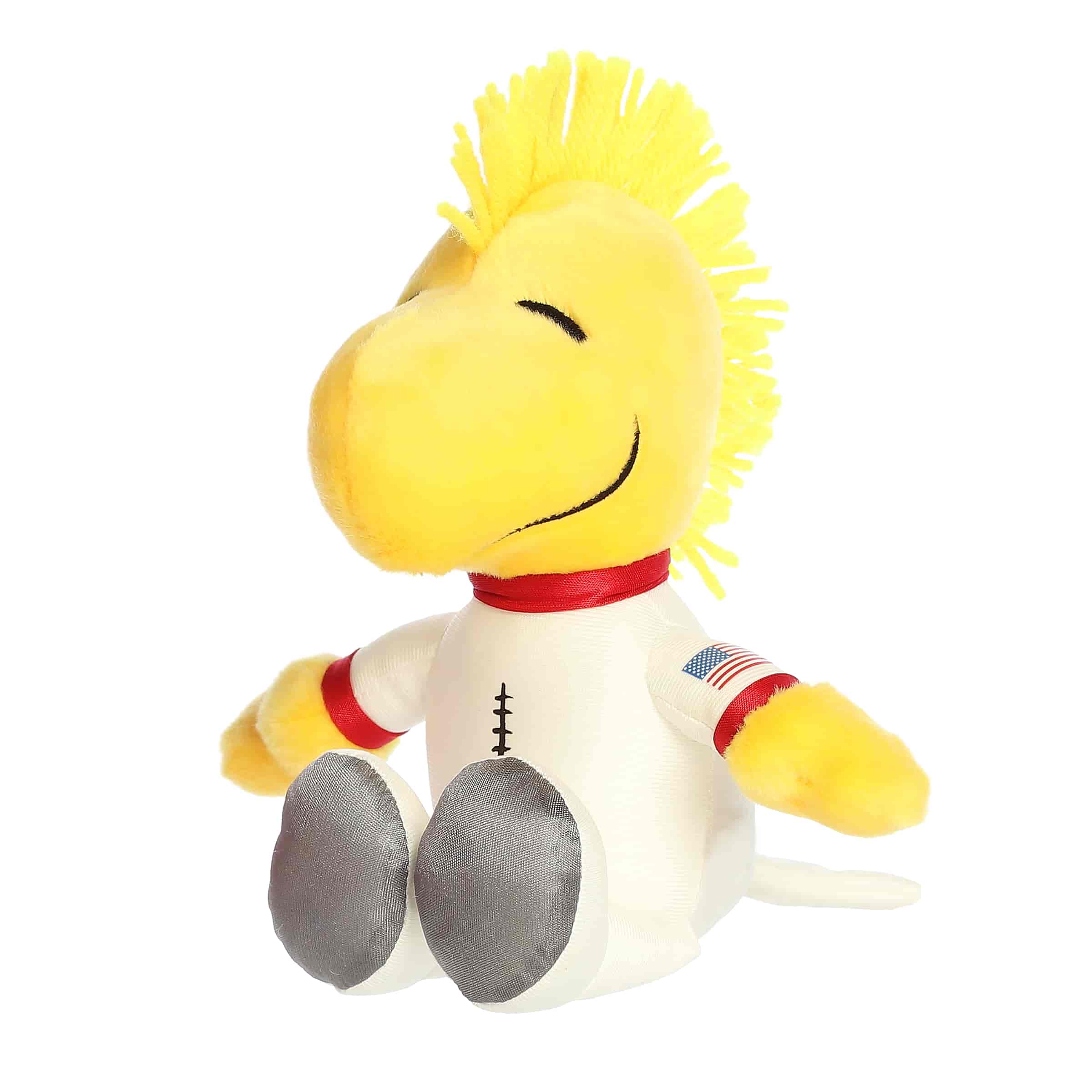 A yellow Woodstock plush wearing a detailed white astronaut suit from the Peanuts collection by Aurora.