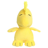 A Woodstock plush toy from Aurora with bright yellow fur, an expressive face, and beans in its feet.