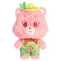 Cheer Bear dressed plush with pink fur, sweet smile, green outfit, and soft rounded ears