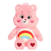 Cheer Bear plush with soft pink fur, smiling face, round ears, and colorful rainbow belly badge