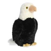 A plush eagle toy from Aurora with a white head, black body, and tan beak and talons.