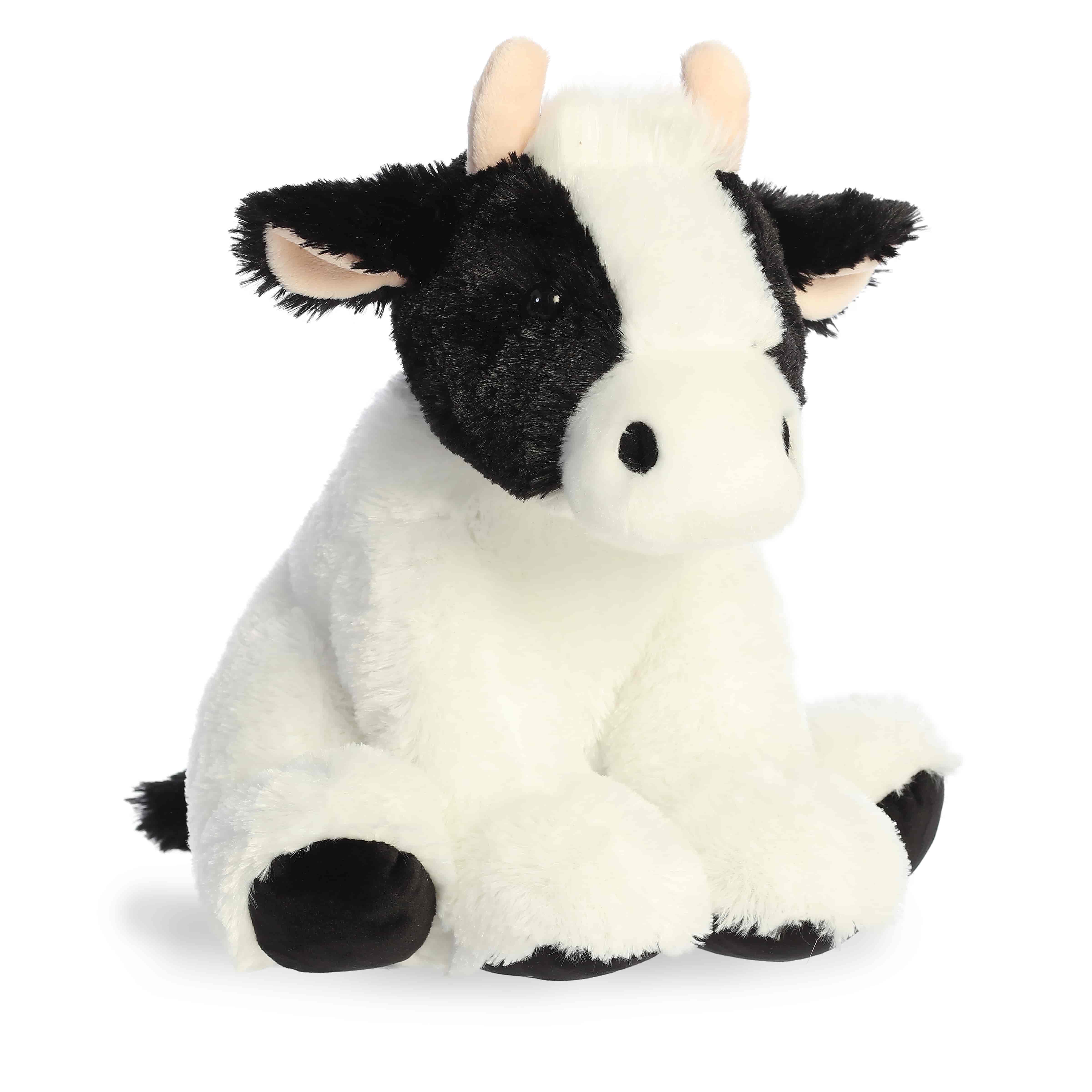 A black-and-white cow plush toy from Aurora with soft fur and floppy legs.