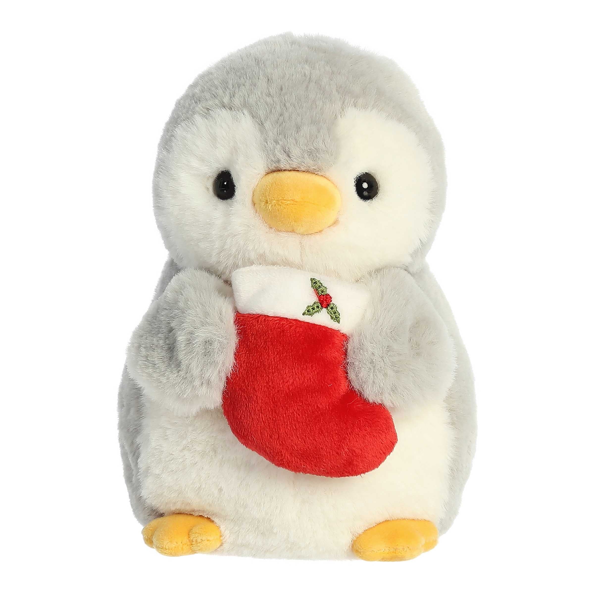 Pompom With Stocking plush penguin from Aurora, holding a festive red stocking, perfect for holiday decor and cuddles.