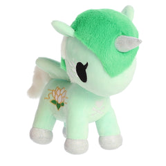 A mint-green unicorn plush with a delicately embroidered water lily emblem on its side.