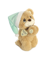 A brown bear plush toy from Precious Moments with a mint green nightcap and paws clasped in prayer.