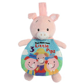A pink pig plush toy from ebba by Aurora with an attached colorful crinkle book themed after the 3 Little Pigs story.