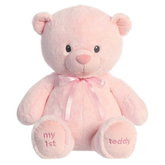 A pink teddy bear plush toy from ebba baby toys with a satin bow and embroidered eyes.