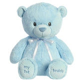 A blue teddy bear plush toy from ebba with embroidered eyes and a matching satin bow.