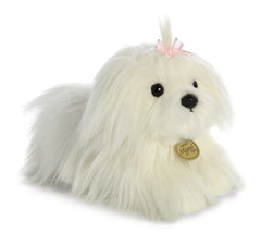 A Maltese puppy plush toy from Miyoni Tots by Aurora with long white fur and a pink bow on its head.