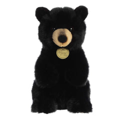 Lifelike black bear cub stuffed animal with luxurious black fur and soulful eyes, crafted for a realistic feel, by Aurora.
