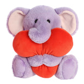Adora Elephant plush from Heart Huggers, enveloped in purple fur, squeezing an oversized heart, valentine's stuffed animal.
