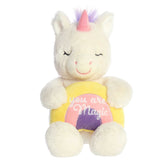 White plush unicorn seated, holding a rainbow with 'You Are Magic', contrasting with a pink horn and purple mane