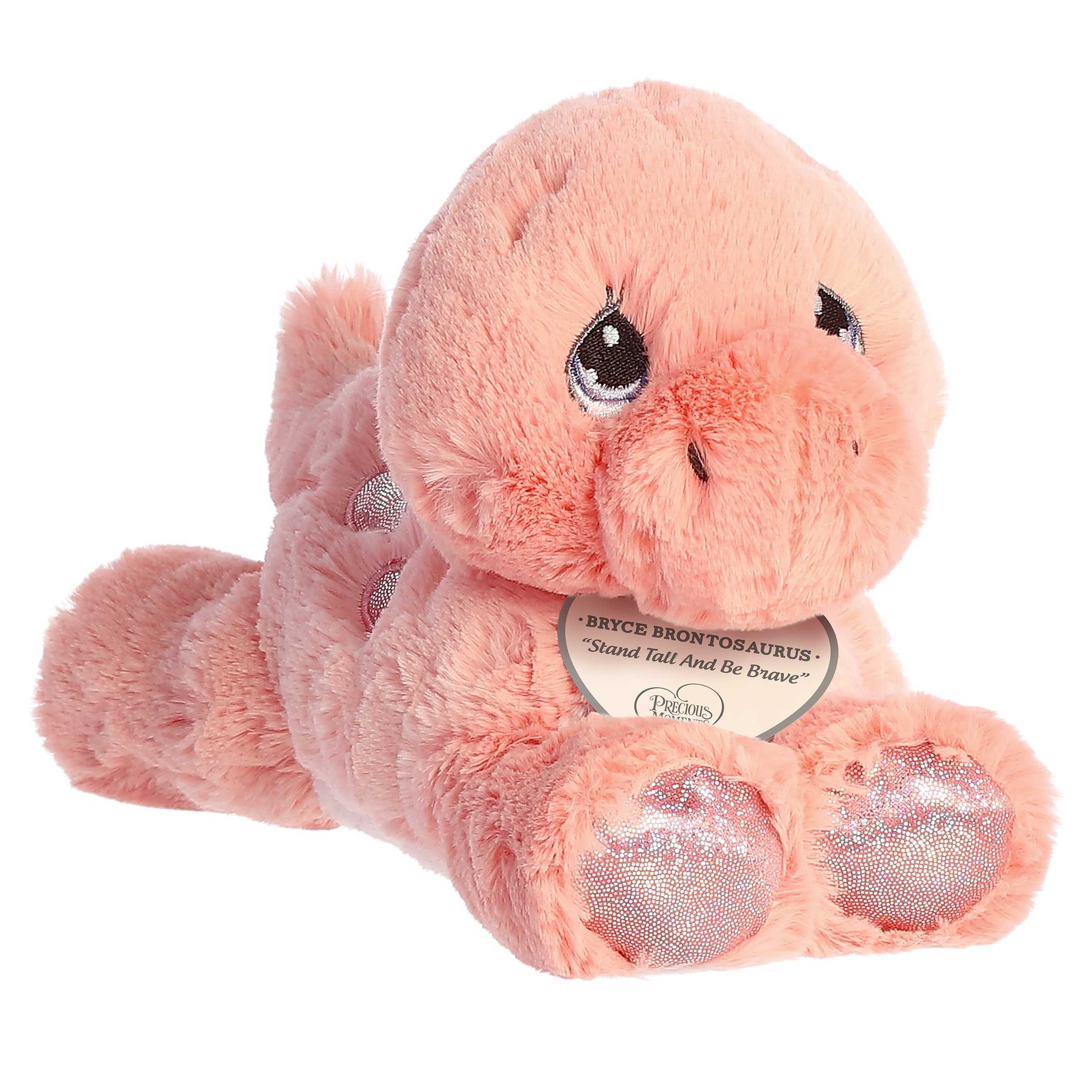 A laying down pink brontosaurus dino plush with tear-drop eyes and an inspirational tag around its neck.