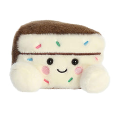 Plush toy of a cake slice in the Palm Pals collection with colorful sprinkles and a joyful expression.