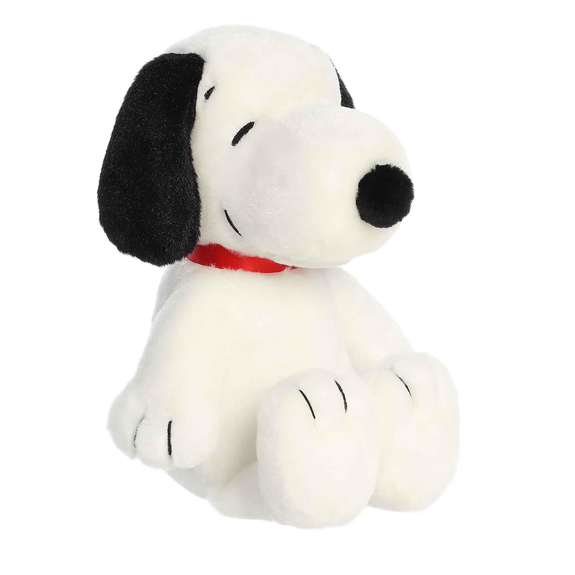 Plush of Snoopy in a relaxed, floppy seated position wearing his classic red collar from the Peanuts® collection.