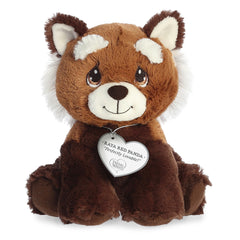 A seated cute red panda plush with tear-drop eyes and a precious moments inspirational tag around its neck.