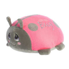 Cute As A Bug Ladybug plush with iconic Precious Moments eyes and "Cute As A Bug" embroidery, in soft pink and gray tones.