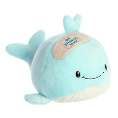 Cute whale plush with a light blue body, bandage detail on its head, smiling face, and a "get Whale soon!" pun written across