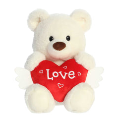 Soft, brown bear plush for Valentine's Day, holding a red heart with white angel wings, embroidered with 'Love'.