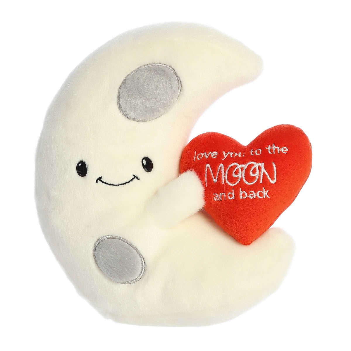 Crescent moon plush with a smiley face, holding a red heart with 'Love You To The Moon and Back', and featuring gray craters.