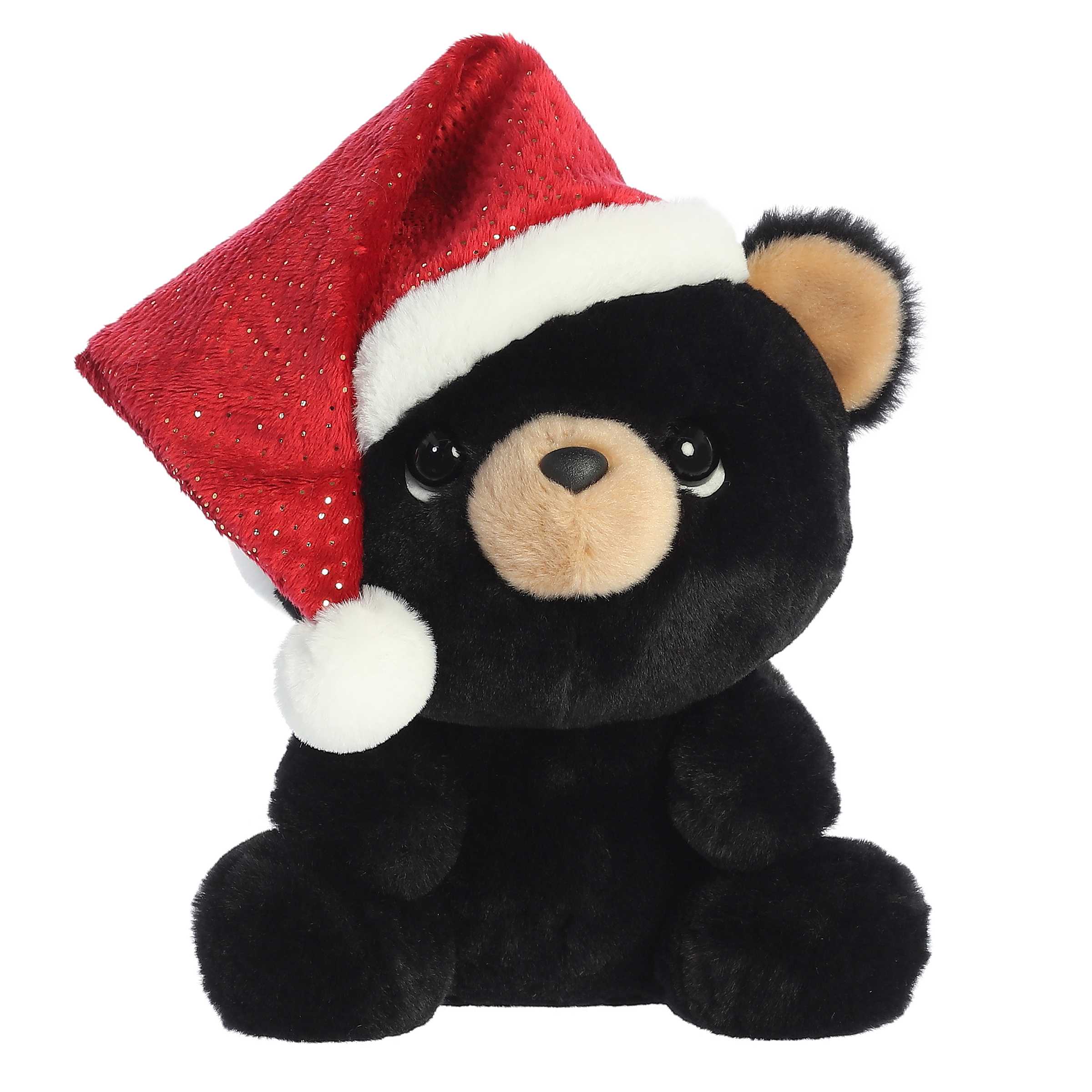 Black teddy bear looking up with endering eyes wearing a giant Santa hat that slides off one side of its cute big head
