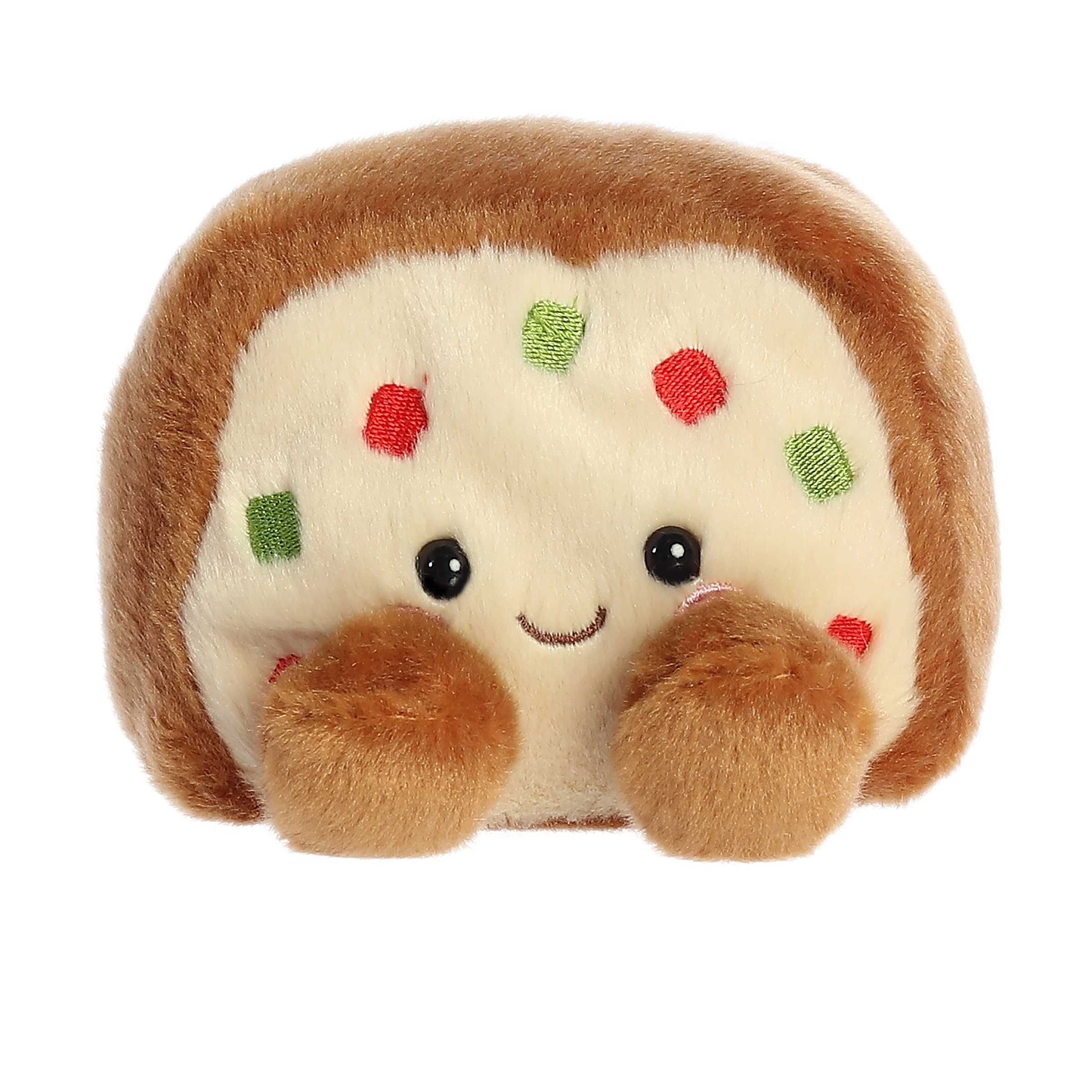 Adorable, happy, mini brown fruit cake plush toy sitting speckled with tiny pieces of red and green fruit