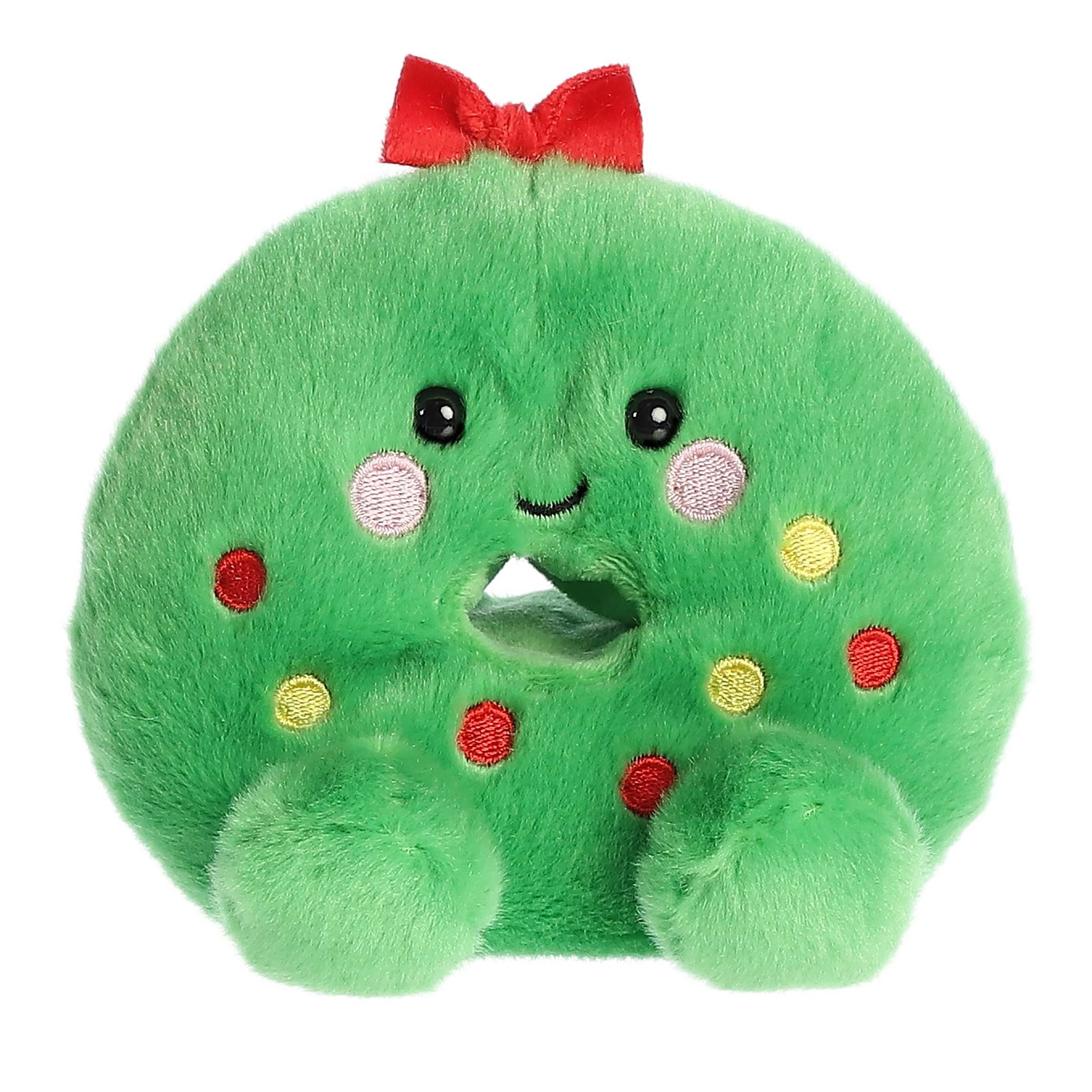 Adorable, happy mini green wreath plush toy sitting speckled with tiny ornaments and topped with a bow