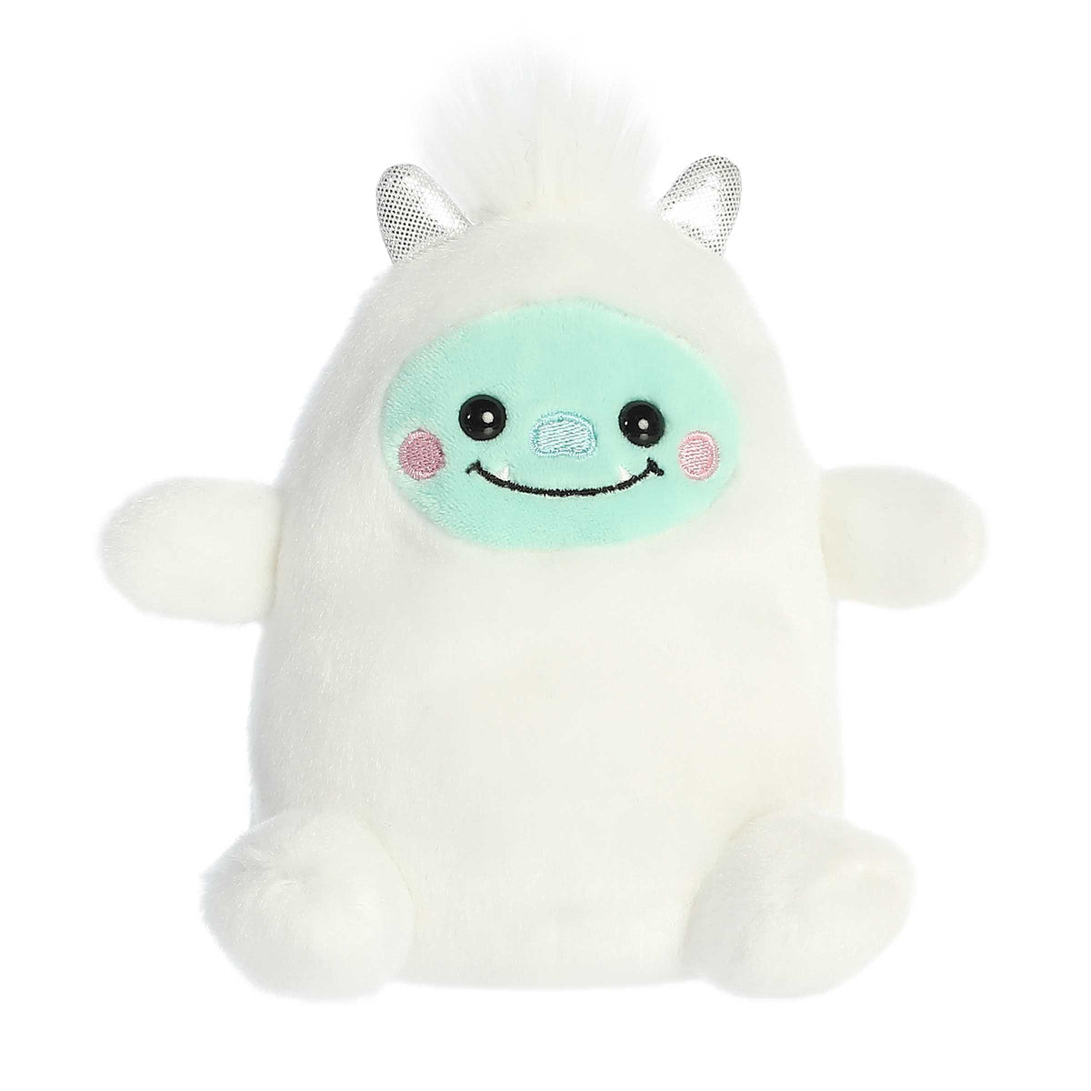 Adorable, happy, mini white yeti plush toy sitting with light blue face, silver horns, and a tuft of hair on top