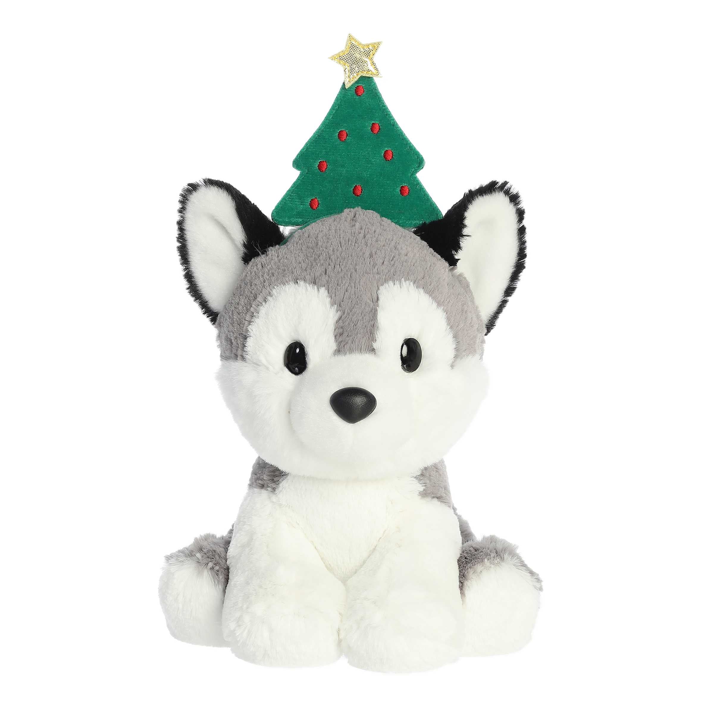 Adorable grey husky with black ears in a sitting position wearing a Christmas tree headband with a star on top